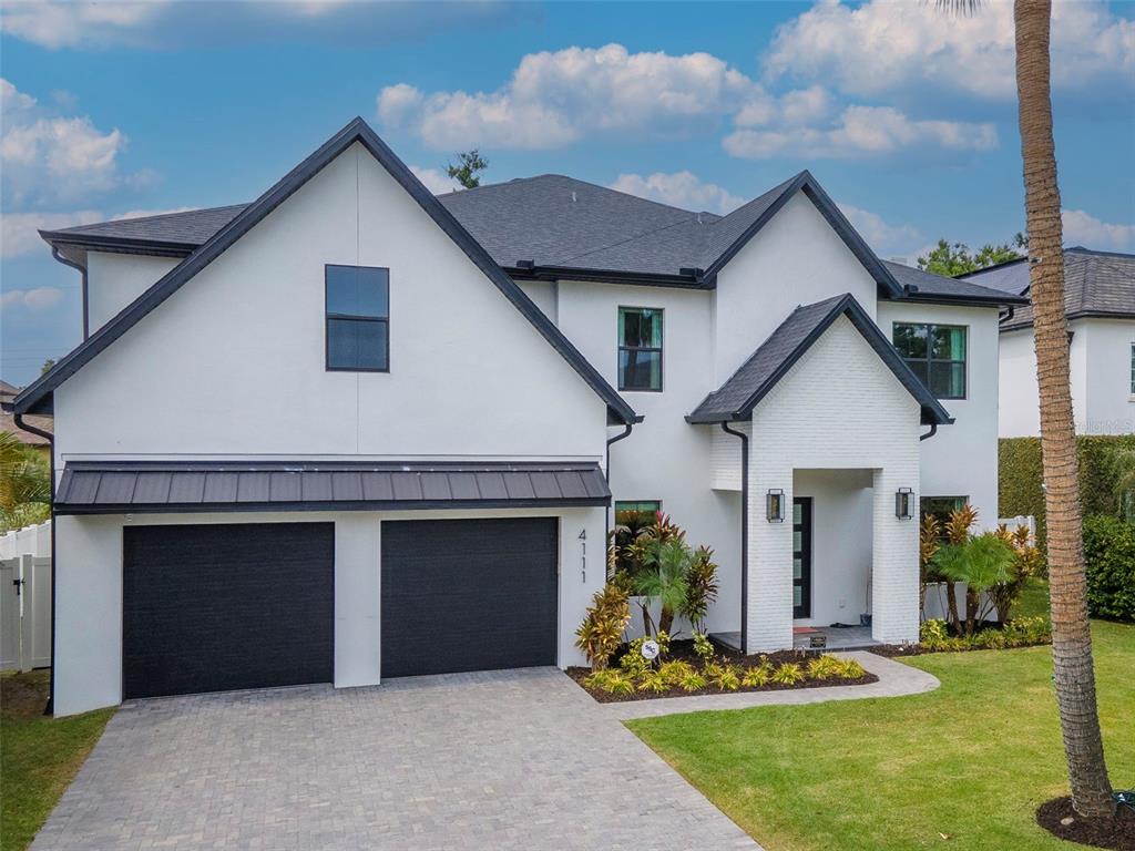 4111 West Swann Avenue Tampa, FL 33609 - Photo 1 of 49 a front view of a house with a garden and plants