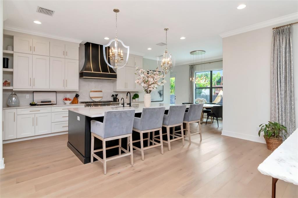 4111 West Swann Avenue Tampa, FL 33609 - Photo 11 of 49 a kitchen with stainless steel appliances a dining table chairs stove refrigerator and cabinets