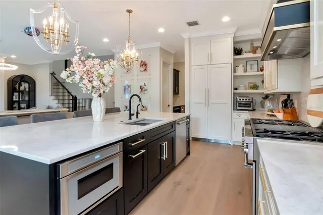 a kitchen with stainless steel appliances a sink stove and cabinets
