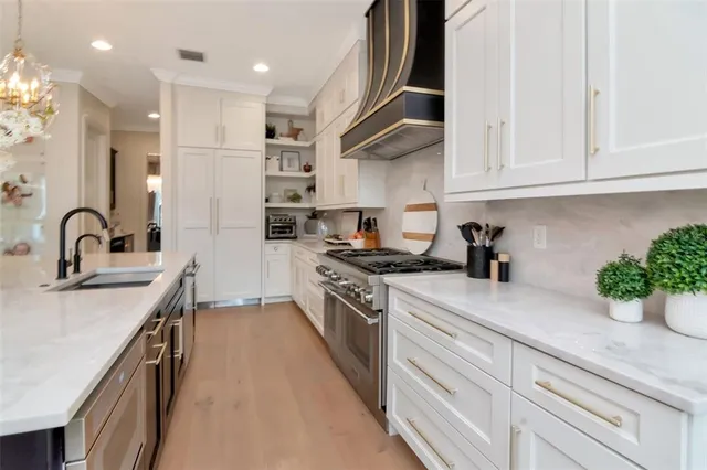 a kitchen with stainless steel appliances granite countertop a sink a stove and a refrigerator