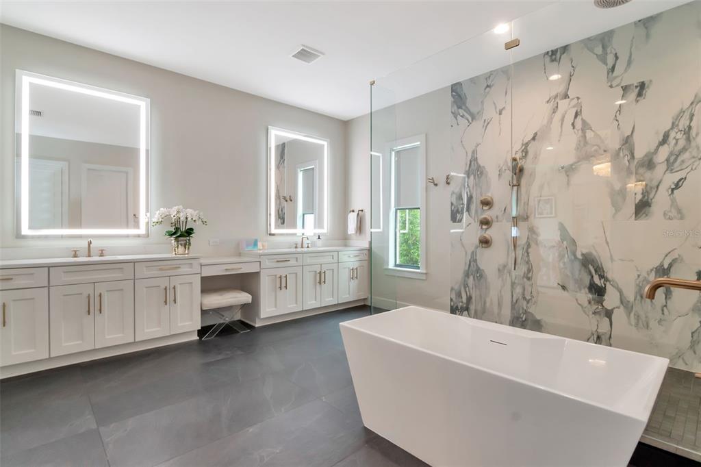 4111 West Swann Avenue Tampa, FL 33609 - Photo 31 of 49 a bathroom with a double vanity sink a mirror a bathtub and a shower