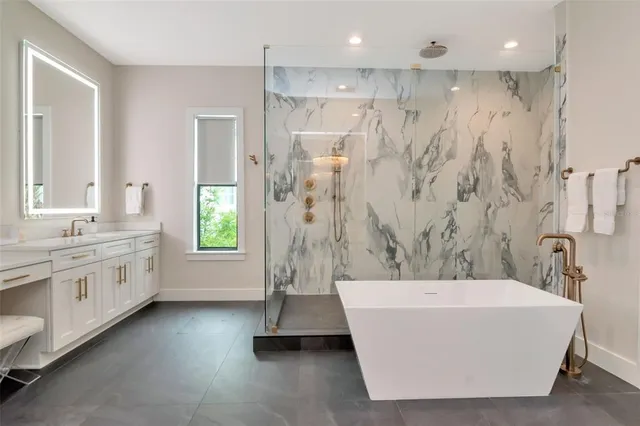 a bathroom with a tub a sink a window and a shower