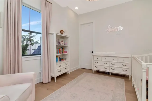 a view of a bedroom with baby crib and cabinet