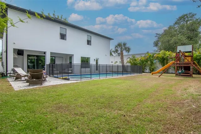 a view of pool with lawn chairs and couches