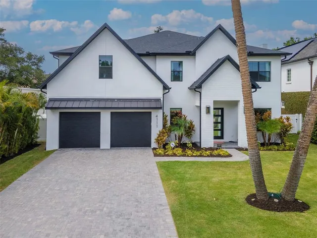 a front view of a house with a yard outdoor seating and garage