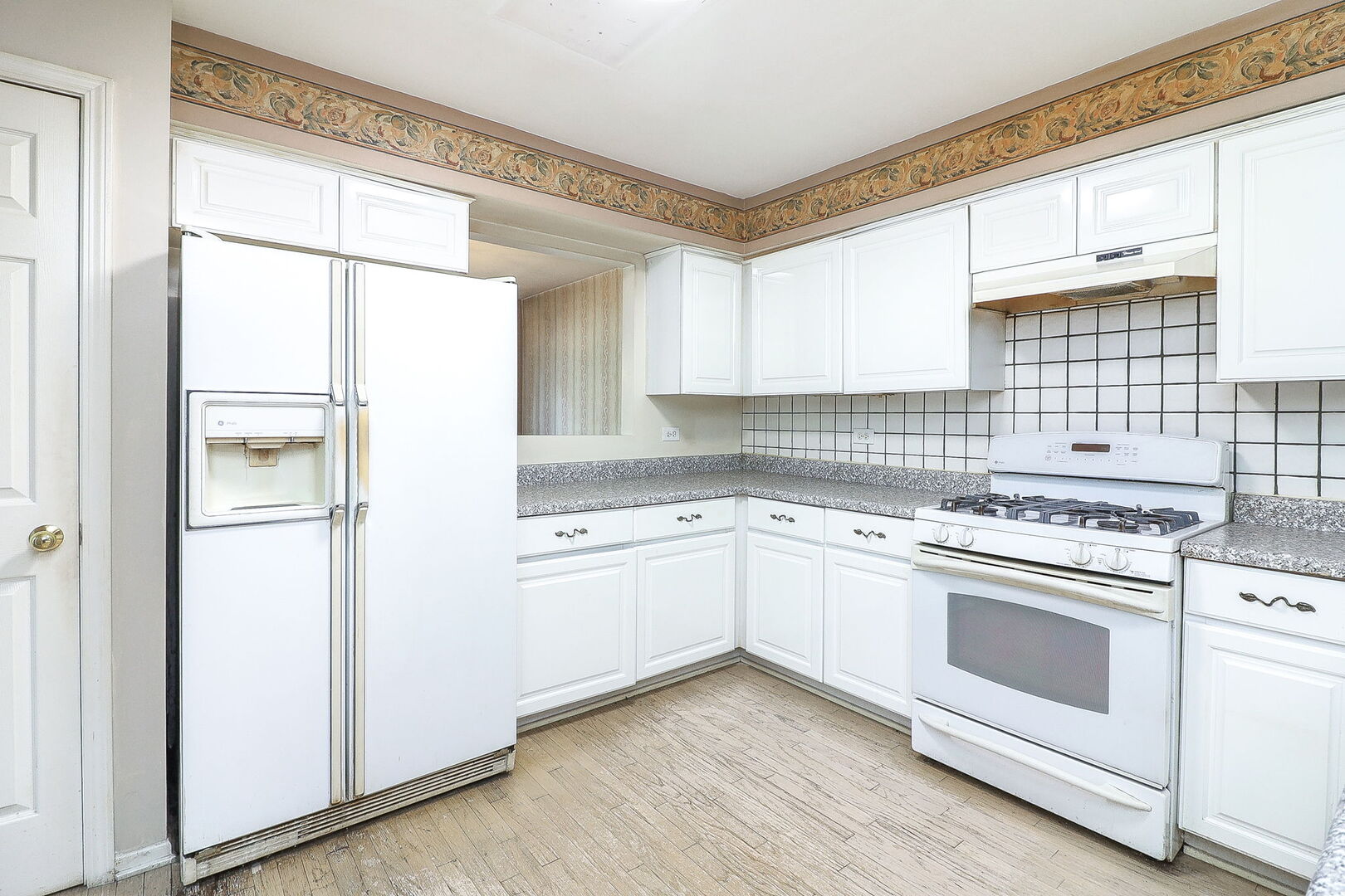 164 Springdale Lane Bloomingdale, IL 60108 - Photo 8 of 30 a kitchen with a stove a sink and white cabinets with wooden floor