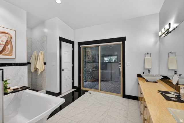 145 Carnesecca Court Mapleton, UT 84664 - Photo 54 of 109 Full bath with a soaking tub, double vanity, and light marble finish floors
