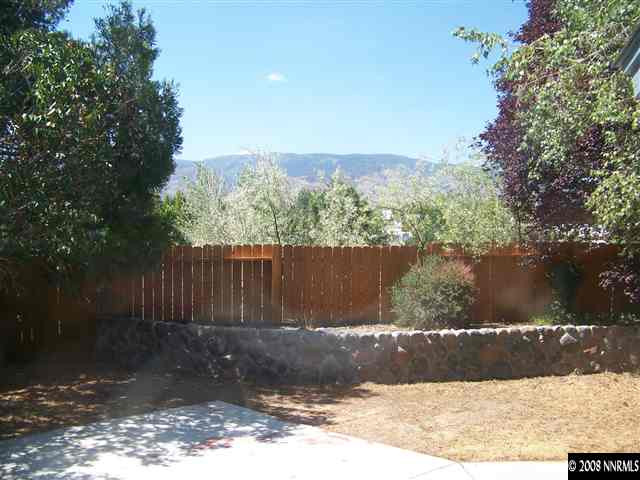 6062 Bankside Way Reno, NV 89523 - Photo 3 of 6 a view of a backyard with large trees and wooden fence