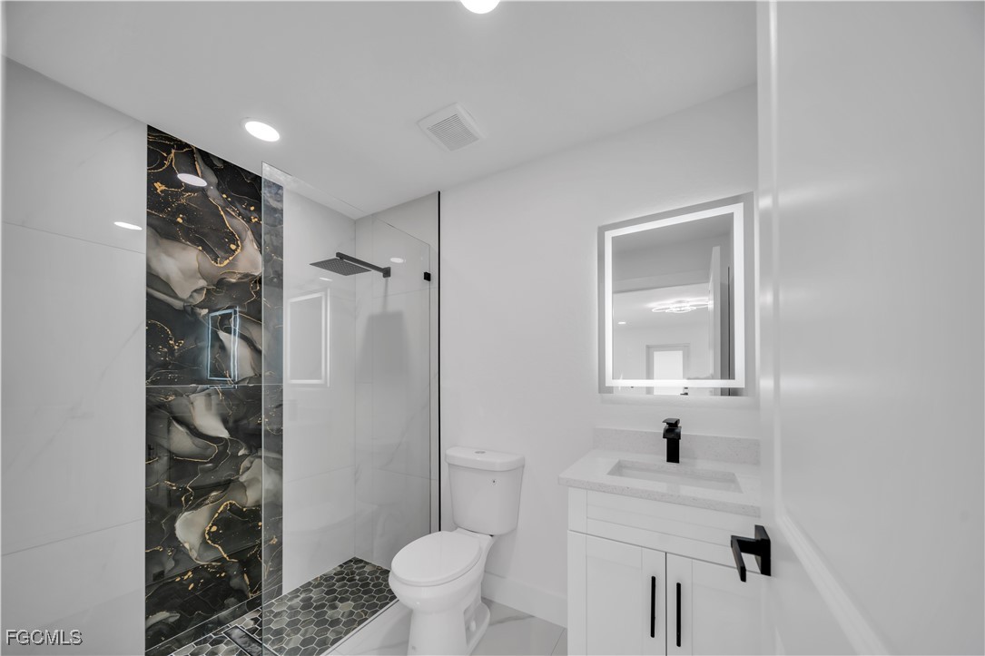 855 Foxtail Street East Lehigh Acres, FL 33974 - Photo 15 of 23 a bathroom with a sink toilet and shower