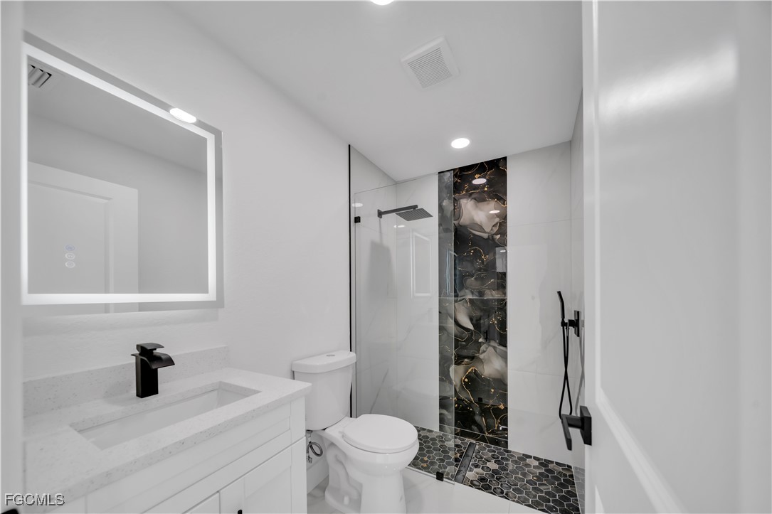 855 Foxtail Street East Lehigh Acres, FL 33974 - Photo 10 of 23 a bathroom with a sink toilet and shower