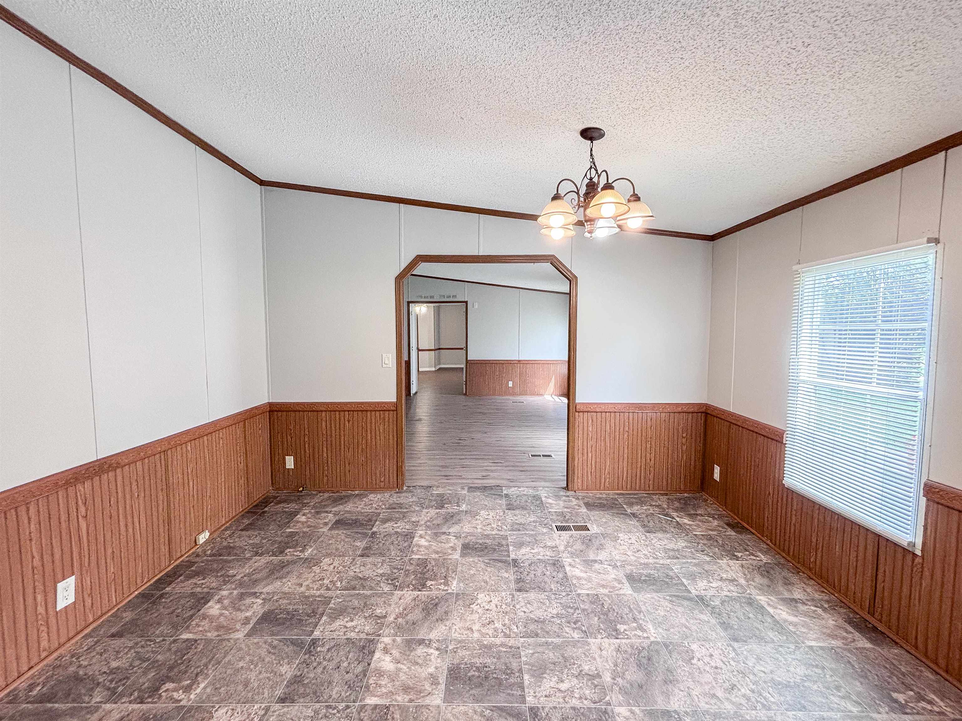 2847 Holly Grove Road Covington, TN 38019 - Photo 13 of 36 Interior room featuring patterned vinyl flooring, wood-finish wainscoting, and a multi-bulb ceiling fixture