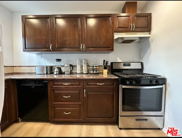 a kitchen with stainless steel appliances granite countertop a stove and a microwave