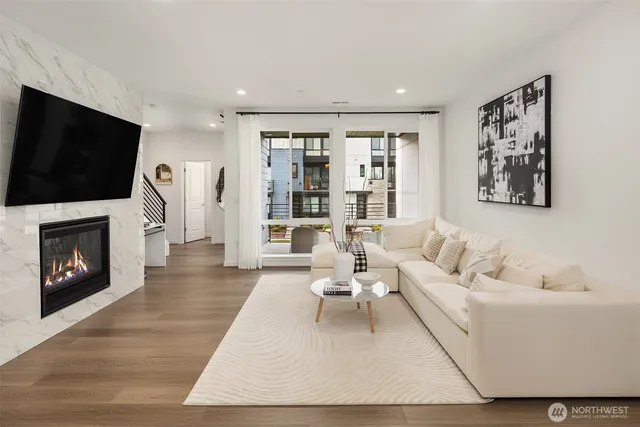 a living room with furniture a flat screen tv and a fireplace