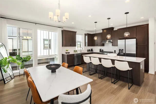 a kitchen with a dining table chairs and sink