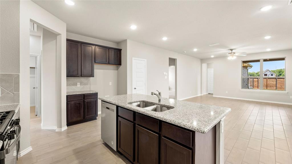 a kitchen with granite countertop sink stainless steel appliances and cabinets
