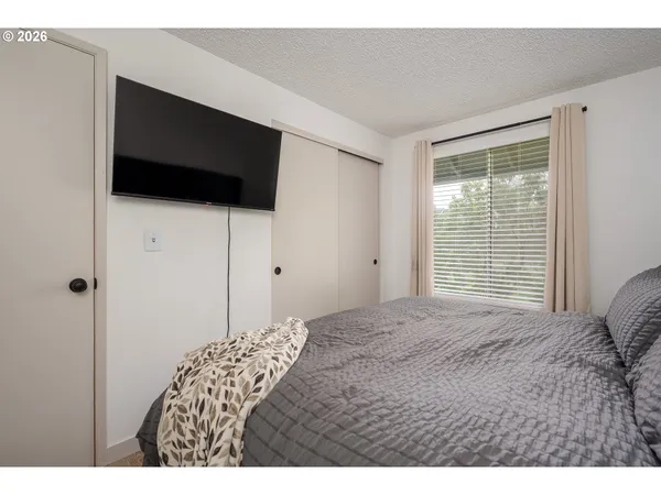 a bedroom with a bed and a flat screen tv