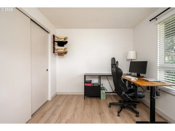 a view of a workspace with furniture and a window