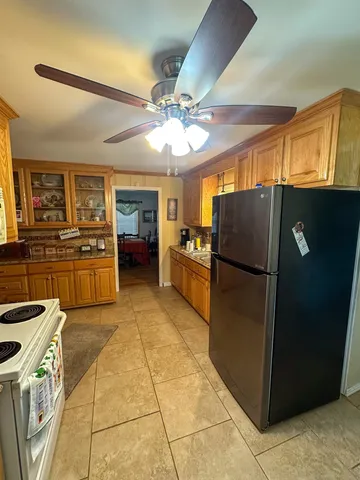 a kitchen with stainless steel appliances granite countertop a refrigerator a sink a stove top oven and cabinets