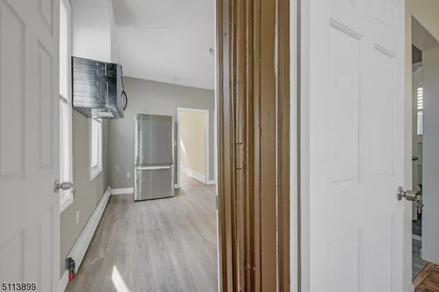 a view of a hallway with wooden floor and closet area