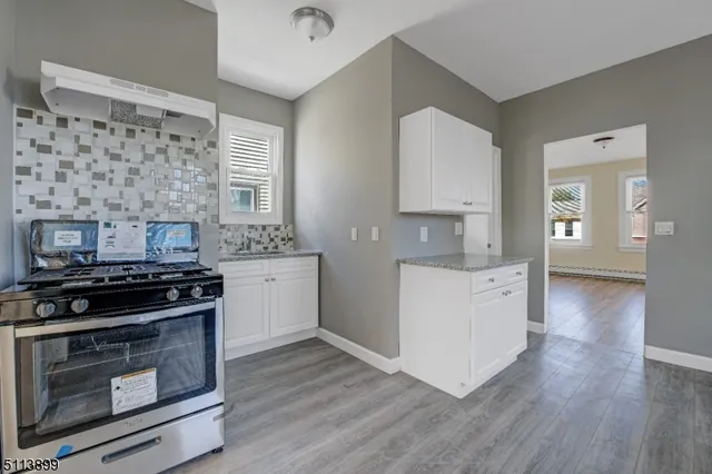 a kitchen with a stove and a wooden floor
