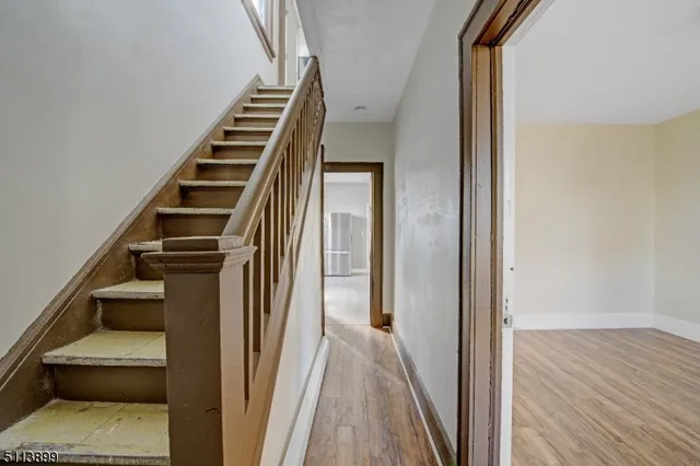 a view of a hallway with wooden floor and entryway