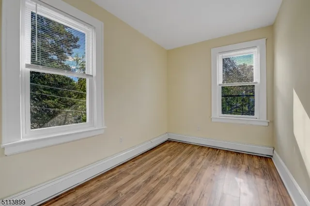 a view of a room with wooden floor and windows