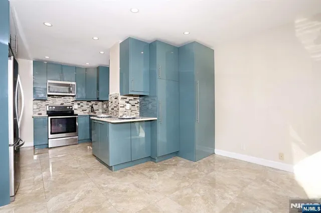a kitchen with stainless steel appliances granite countertop a stove sink and refrigerator