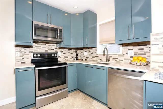 a kitchen with stainless steel appliances granite countertop a sink stove and microwave