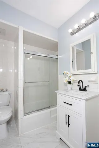 a bathroom with a sink toilet a mirror and shower