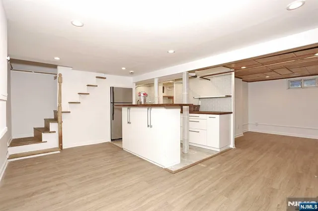 a kitchen with granite countertop a refrigerator and a stove top oven