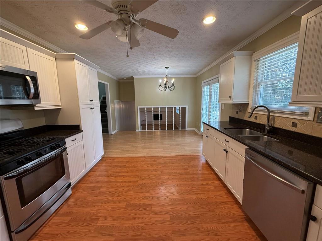 7719 Glen Devon Road Jonesboro, GA 30236 - Photo 10 of 37 a large kitchen with stainless steel appliances granite countertop a stove and a sink