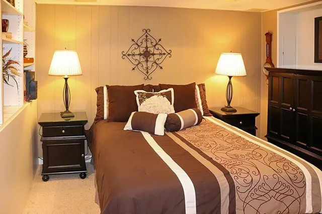 a bedroom with a bed and a lamp on dresser