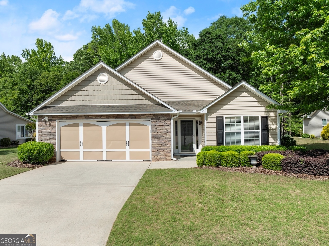 a front view of a house with a garden and plants