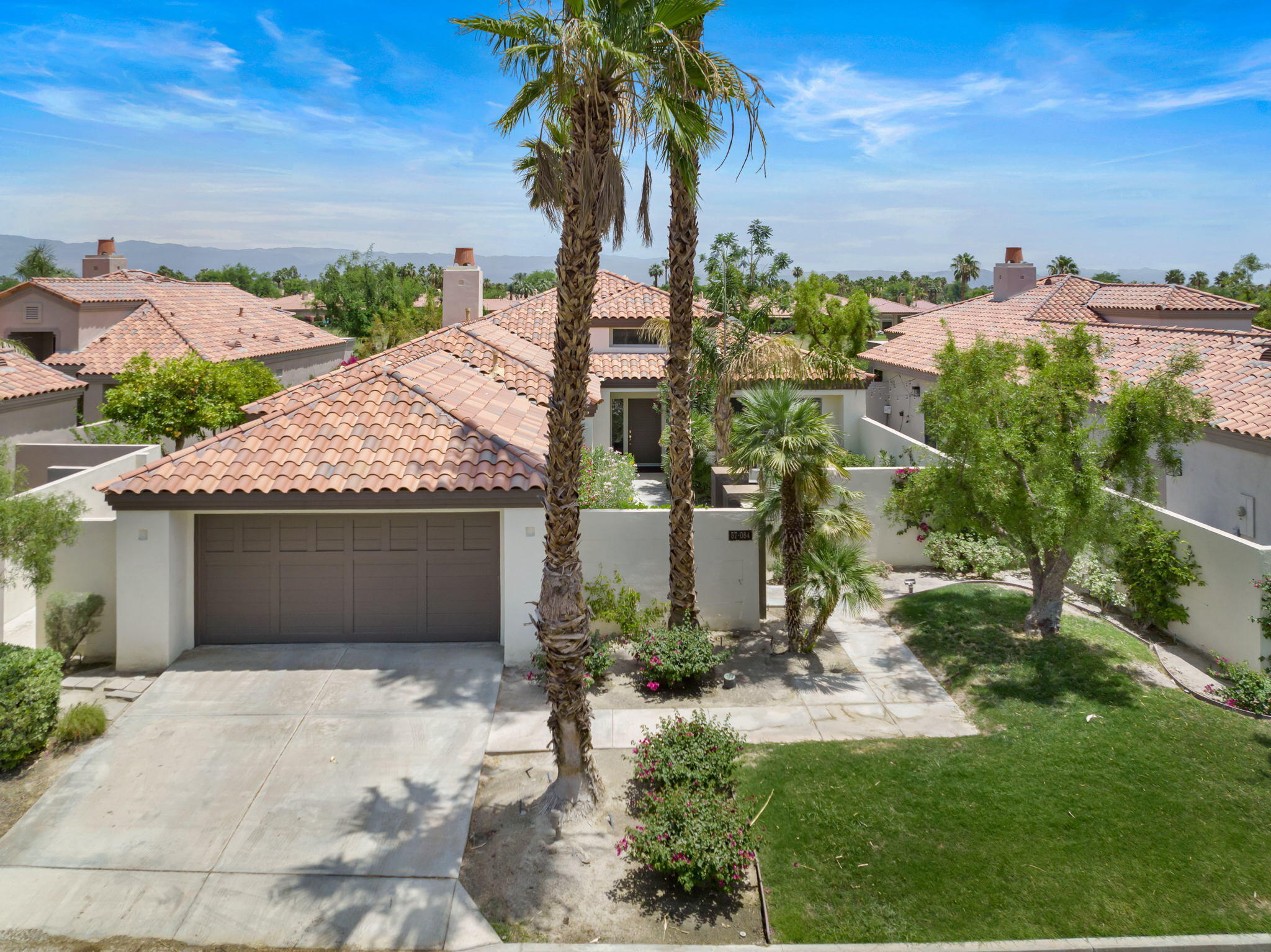 57084 Merion La Quinta, CA 92253 - Photo 2 of 56 a front view of a house with a garden and yard