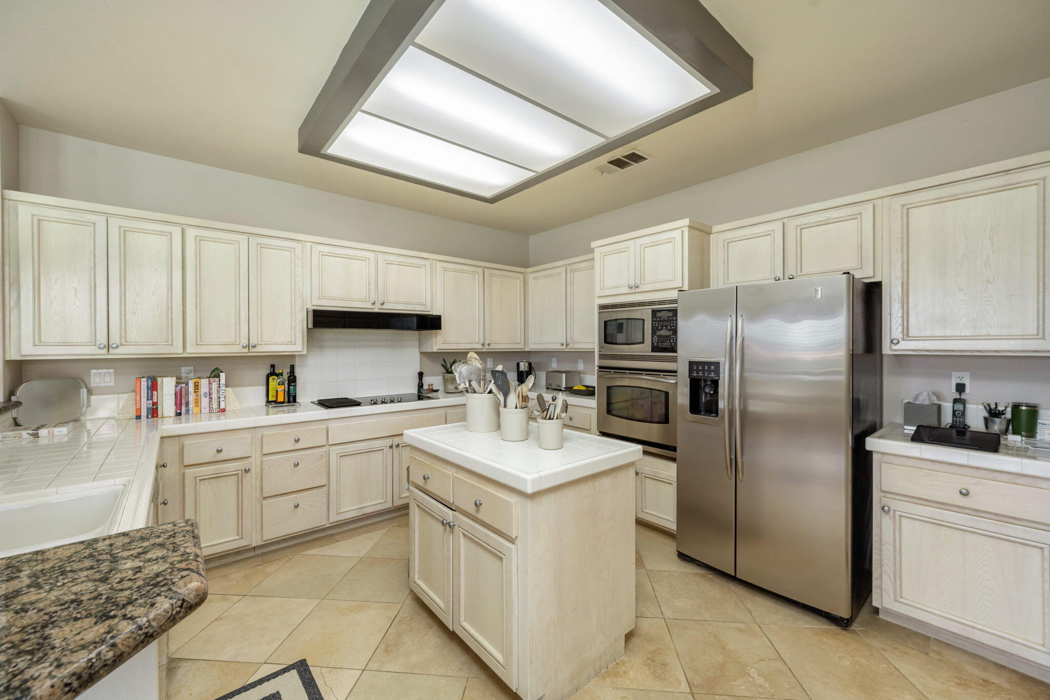 57084 Merion La Quinta, CA 92253 - Photo 35 of 56 a kitchen with a sink stainless steel appliances and white cabinets