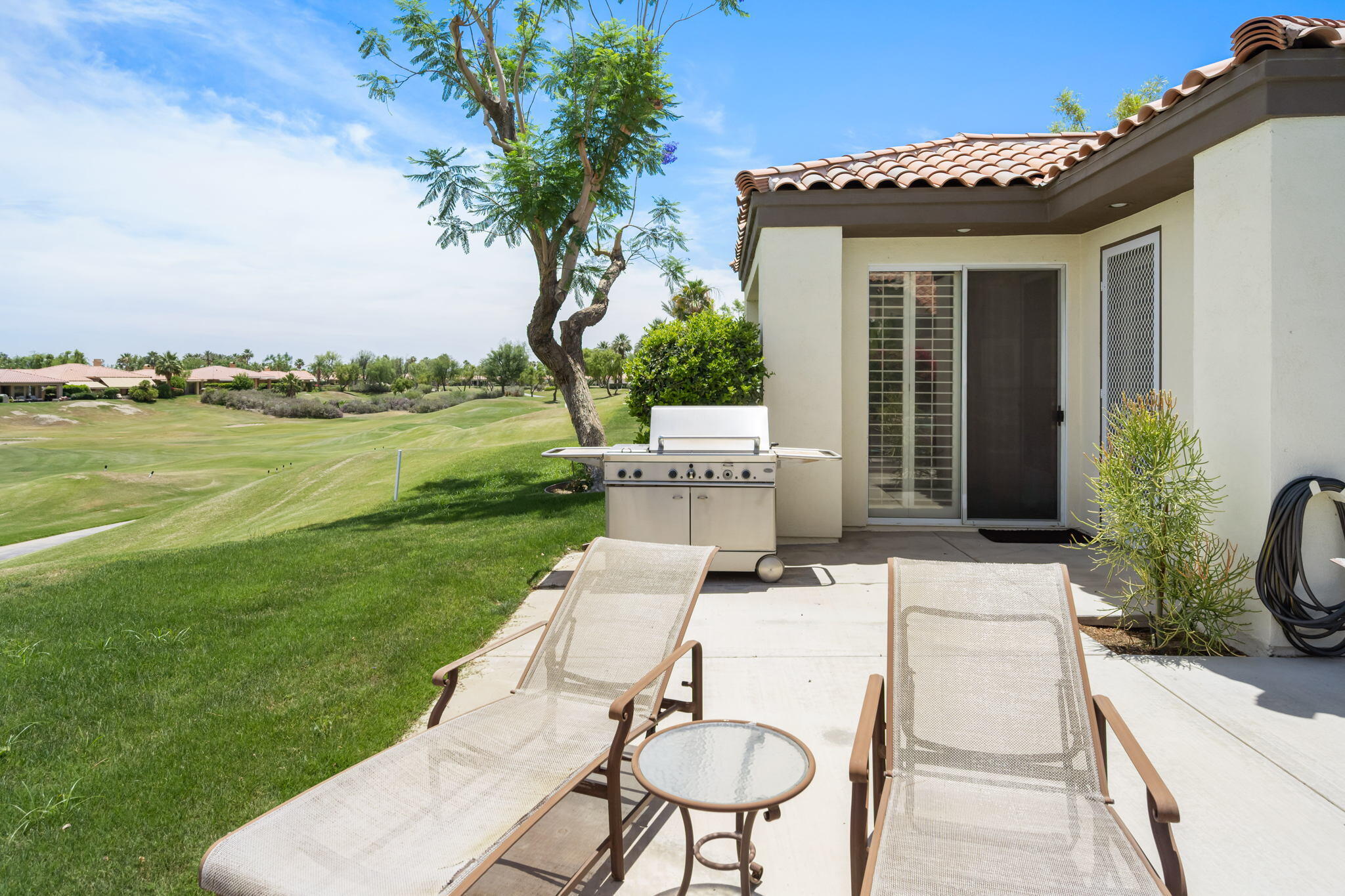 57084 Merion La Quinta, CA 92253 - Photo 45 of 56 a view of a patio with table and chairs potted plants with wooden floor and fence