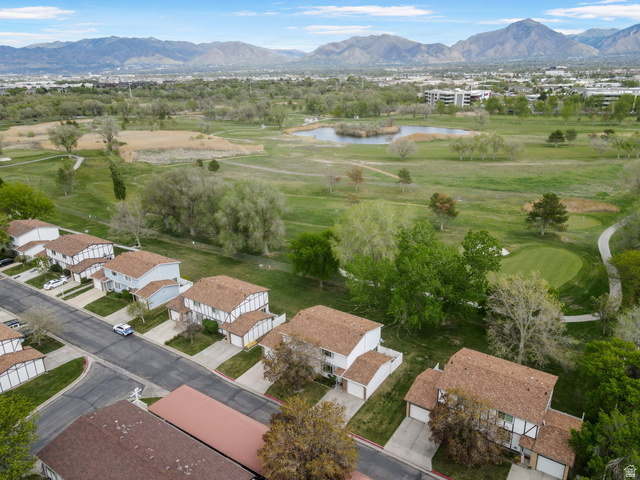 Aerial view of residential area featuring a water and mountain view and a golf club