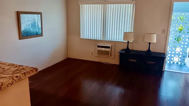 a view of a livingroom with wooden floor and a cabinet