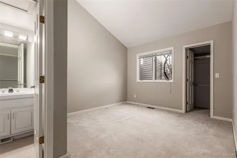 a view of an empty room with a bathroom and a window