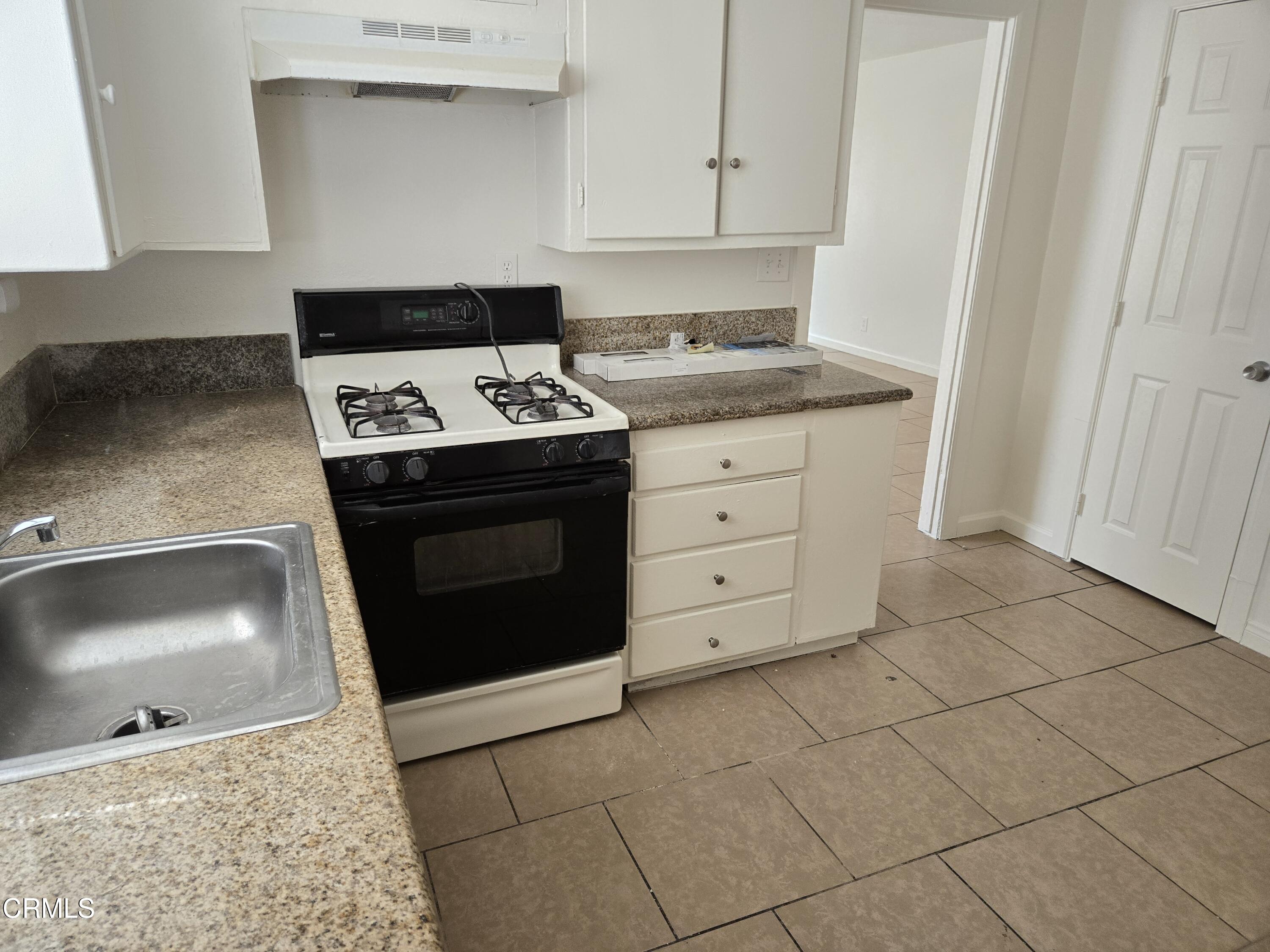 44226 2nd Street East Lancaster, CA 93535 - Photo 3 of 12 a kitchen with granite countertop white cabinets and appliances