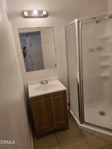 a bathroom with a sink a shower and a mirror