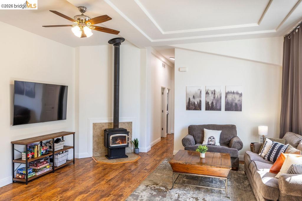 20828 Ferretti Road Groveland, CA 95321 - Photo 2 of 60 Living area featuring wood finished floors, a wood stove, ceiling fan, and lofted ceiling