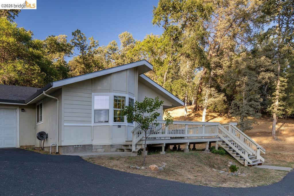 20828 Ferretti Road Groveland, CA 95321 - Photo 30 of 60 View of property exterior featuring a deck, an attached garage, and asphalt driveway