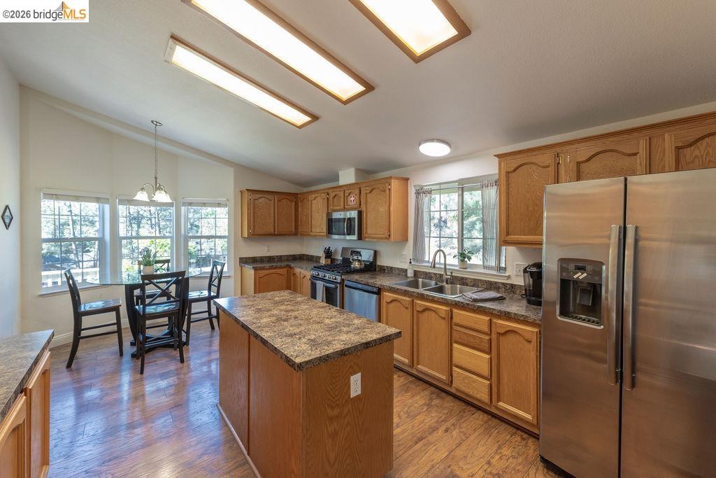 20828 Ferretti Road Groveland, CA 95321 - Photo 3 of 60 Kitchen with stainless steel appliances, a kitchen island, dark wood-type flooring, wood finish cabinetry, and lofted ceiling