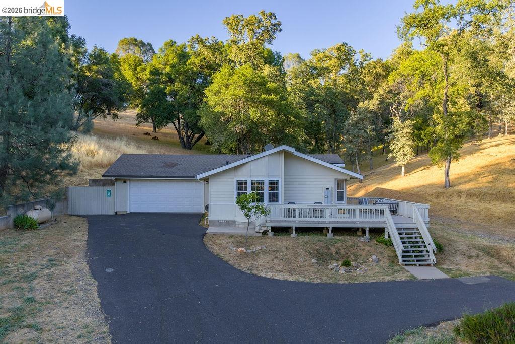 20828 Ferretti Road Groveland, CA 95321 - Photo 37 of 60 Ranch-style house featuring a deck, driveway, an attached garage, and view of scattered trees