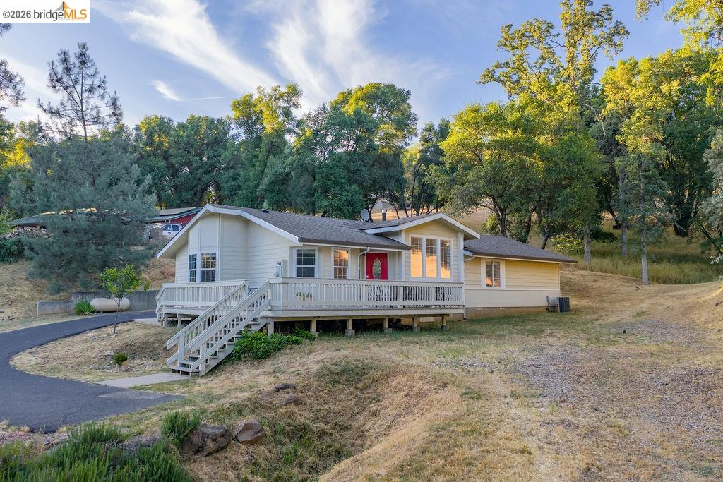 20828 Ferretti Road Groveland, CA 95321 - Photo 55 of 60 View of front facade with a chimney, view of wooded area, and a wooden deck