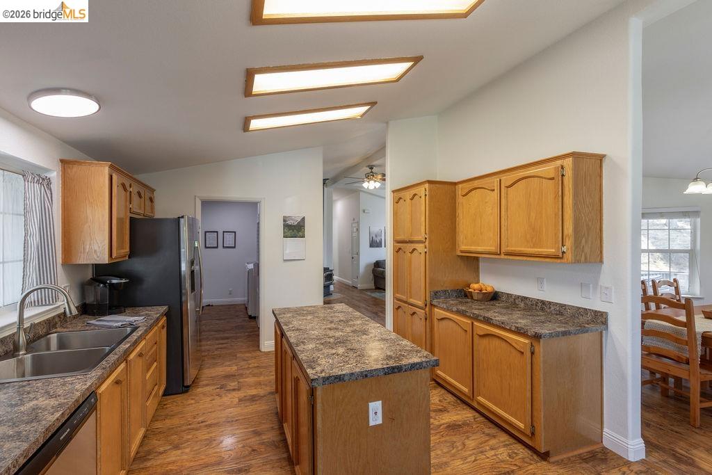 20828 Ferretti Road Groveland, CA 95321 - Photo 9 of 60 Kitchen featuring dark countertops, lofted ceiling, a center island, dark wood-style flooring, and stainless steel appliances