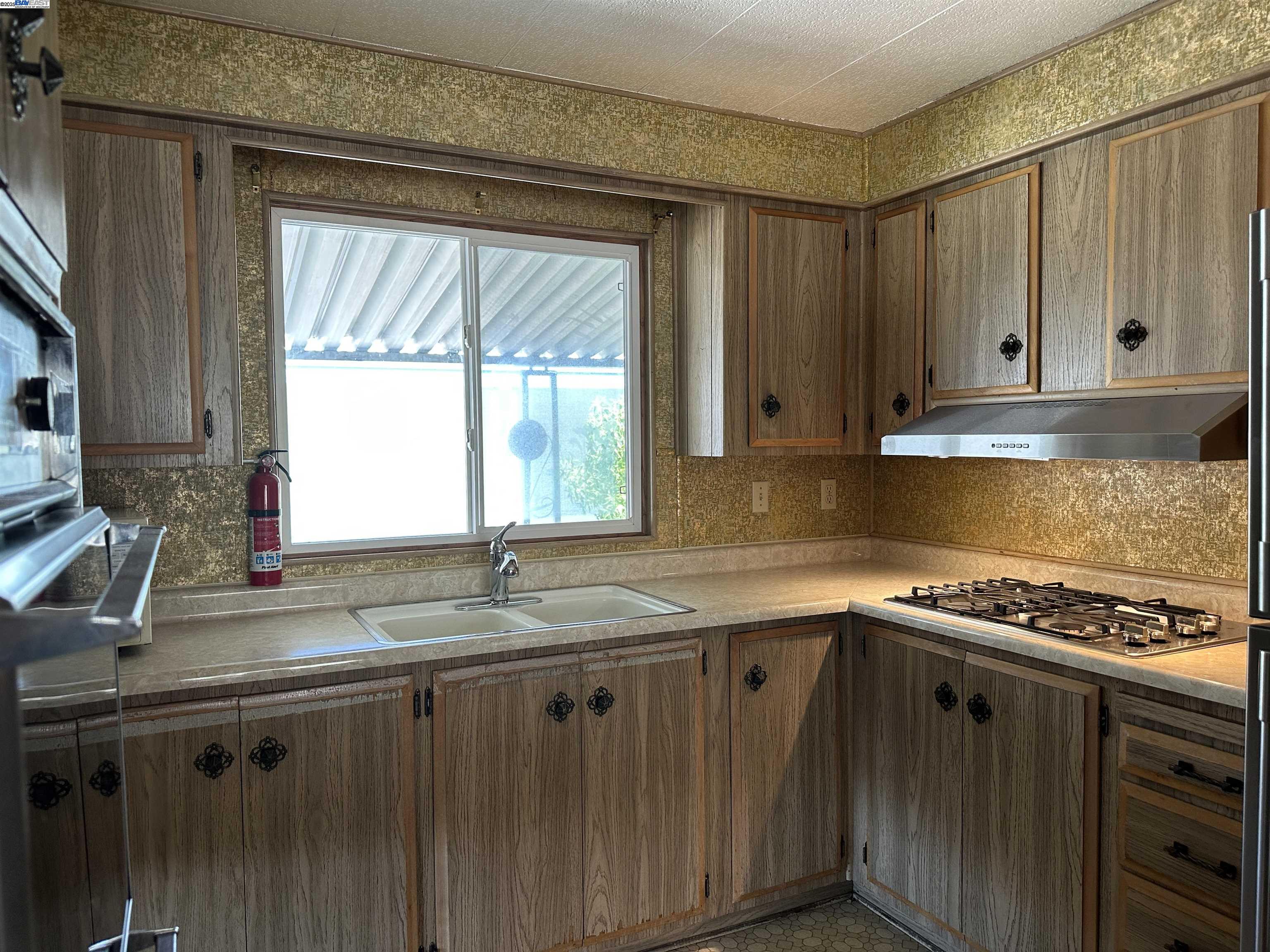 711 Old Canyon Road, Unit 77 Fremont, CA 94538 - Photo 16 of 39 a kitchen with granite countertop a sink a stove and cabinets
