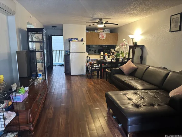 a living room with furniture and a flat screen tv with kitchen view
