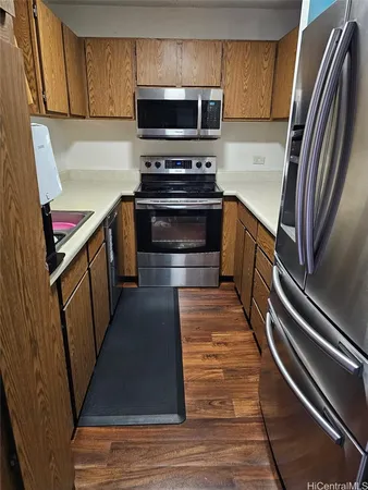 a kitchen with granite countertop a refrigerator and a stove top oven